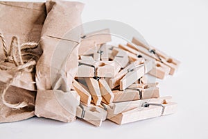 Wooden clothespins in paper bag with rope on white background. View from above. Place for your text