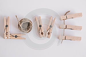 Wooden clothespins with rope on white background with the inscription the word love. View from above. Place for your text