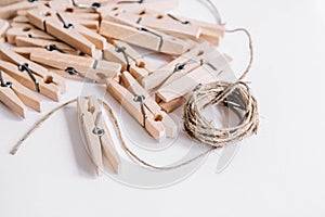 Wooden clothespins with rope on white background. View from above. Copy space