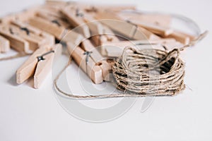 Wooden clothespins with rope on white background. View from above. Copy space