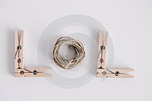 Wooden clothespins with rope on white background. View from above. Copy space