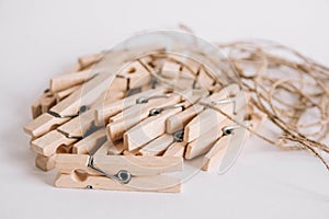 Wooden clothespins with rope on white background. View from above. Place for your text