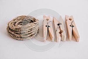 Wooden clothespins with rope on white background. View from above. Place for your text