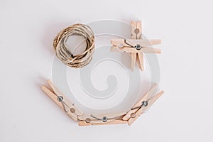Wooden clothespins with rope on white background which are composed in the form of a smile icon. View from above. Place for your
