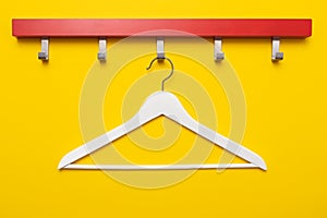 Wooden coat hanger or clothes hanger on a colored background