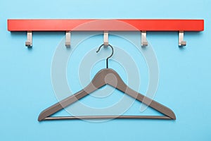 Wooden coat hanger or clothes hanger on a colored background