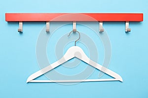 Wooden coat hanger or clothes hanger on a colored background