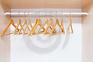 Wooden coat hangers on clothes rail