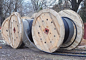 Wooden coil of electric cable and optical fibres on construction site.