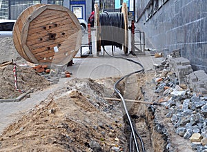 Wooden coil of electric cable and optical fibres in the digging on the street photo