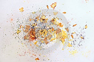 Wooden colored pencil sharpening shavings pile on white background