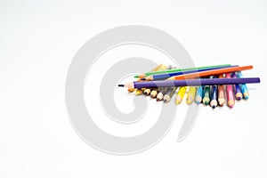 Wooden colored pencils on a white background with a point (lead) in focus