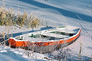 Wooden colorful boat stacked on a frozen lake