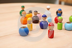 Wooden colorful dolls shaped building blocks on table, closeup. Montessori toy