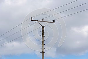 Wooden column of electric wiring with electric wires against the sky in a snowy landscape