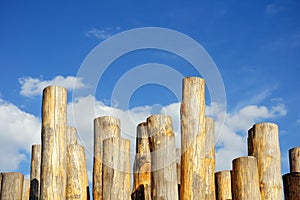 Wooden columns against cloudy blue sky