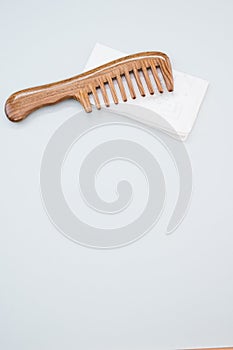 Wooden comb isolated on a white handkerchief on a gray background