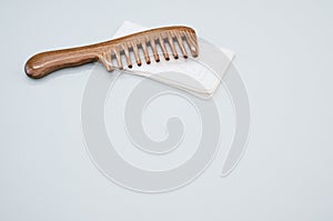 Wooden comb isolated on a white handkerchief on a gray background