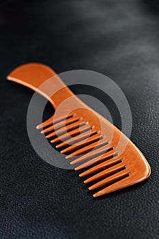 A wooden comb on a nevy blue background