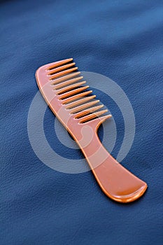 A wooden comb on a nevy blue background