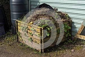 Wooden compost bin full of rotting vegetation garden waste