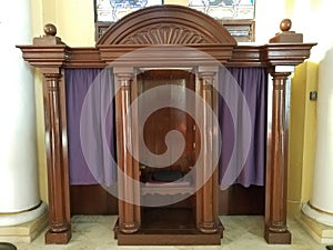 Wooden confession booth with purple curtain or fabric