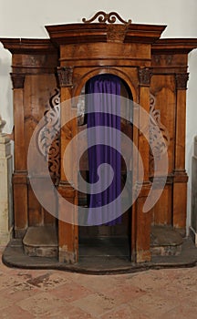 Wooden confessional inside a church with curtain photo