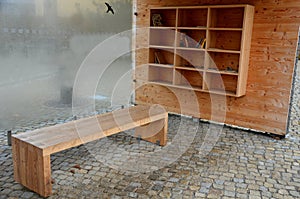 Wooden construction of the bus stop, shelter of a gazebo pergola with a bench and shelves for storing books and magazines. the wal