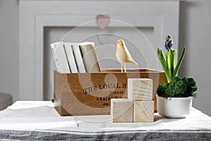 Wooden container with books, three cubes on the table against the background of a white fireplace. Place for text. Valentine`s Da