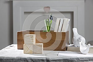 Wooden container with books, three cubes on table against the background of a white fireplace. Place for text. Valentine`s Da