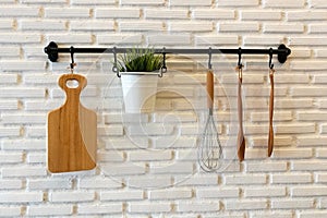 Wooden cookware on kitchen brick wall