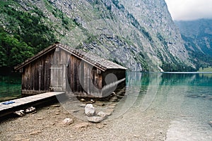 Wooden cottage in beautiful lake in the Alps with misty mood