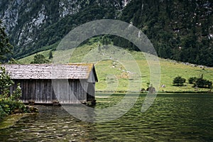 Wooden cottage in beautiful lake in the Alps with misty mood