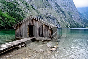 Wooden cottage in beautiful lake in the Alps with misty mood