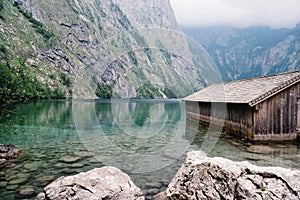 Wooden cottage in beautiful lake in the Alps with misty mood