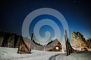 Wooden cottage with blue starry sky at night