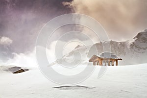 Wooden cottage and snow covered huts in blizard