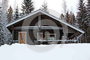 Wooden cottage in winter forest