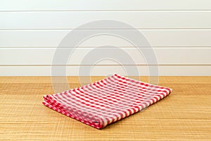 Wooden counter with red checked tablecloth for product montage background