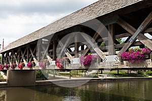 Wooden Covered Bridge with Colorful Flowers over the DuPage River along the Naperville Riverwalk in Suburban Naperville Illinois d