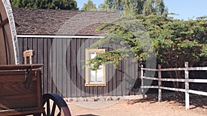 Wooden covered wagon on wheels, wild west pioneer ranch. Western farm or saloon.