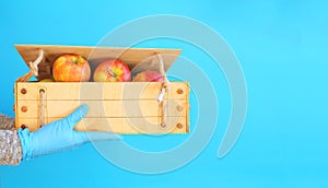 Wooden crate box full of fresh apples isolated on a red background