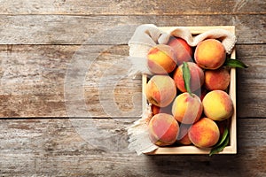Wooden crate with fresh sweet peaches photo