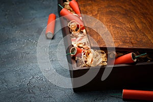 Wooden crate with red dynamite firecracker tnt sticks on table