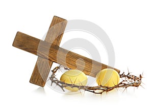Wooden cross, crown of thorns and Easter eggs on white