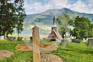 A wooden cross in front of the RÃ¸dven Stave Church