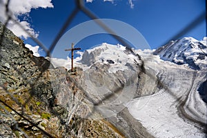 Wooden cross and glacier take through the net at Gornergrat stat
