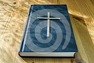 Wooden cross of God on the Bible, study of religion at home