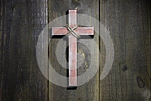 Wooden cross hanging on rustic wooden background