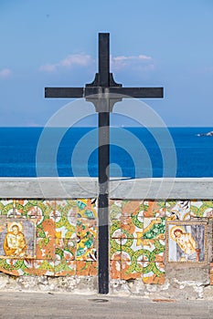 Wooden cross with a low wall decorated with religious icons overlooking the sea. Location: Forio, Soccorso Church photo